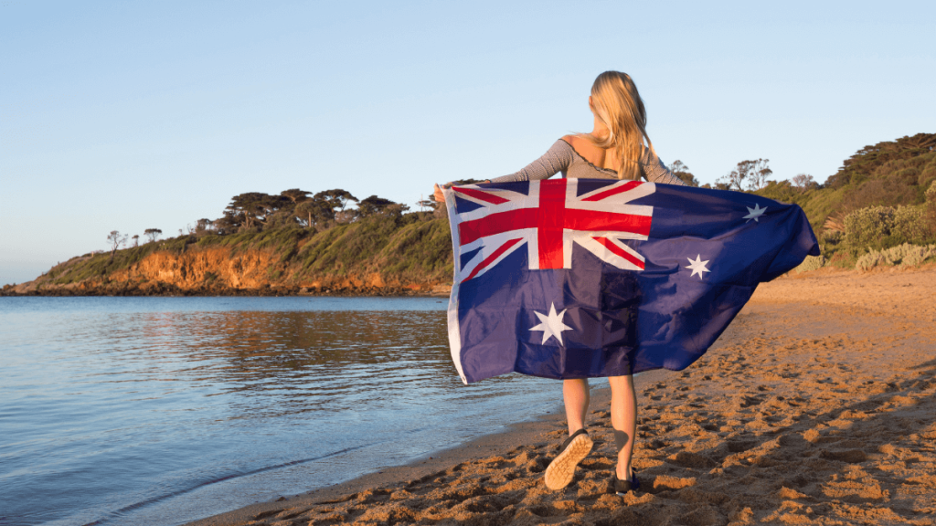 a woman holding a flag on a beach