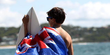 a young australian with a flag at a beach