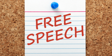 free speech written on an index paper pinned on a bulletin board